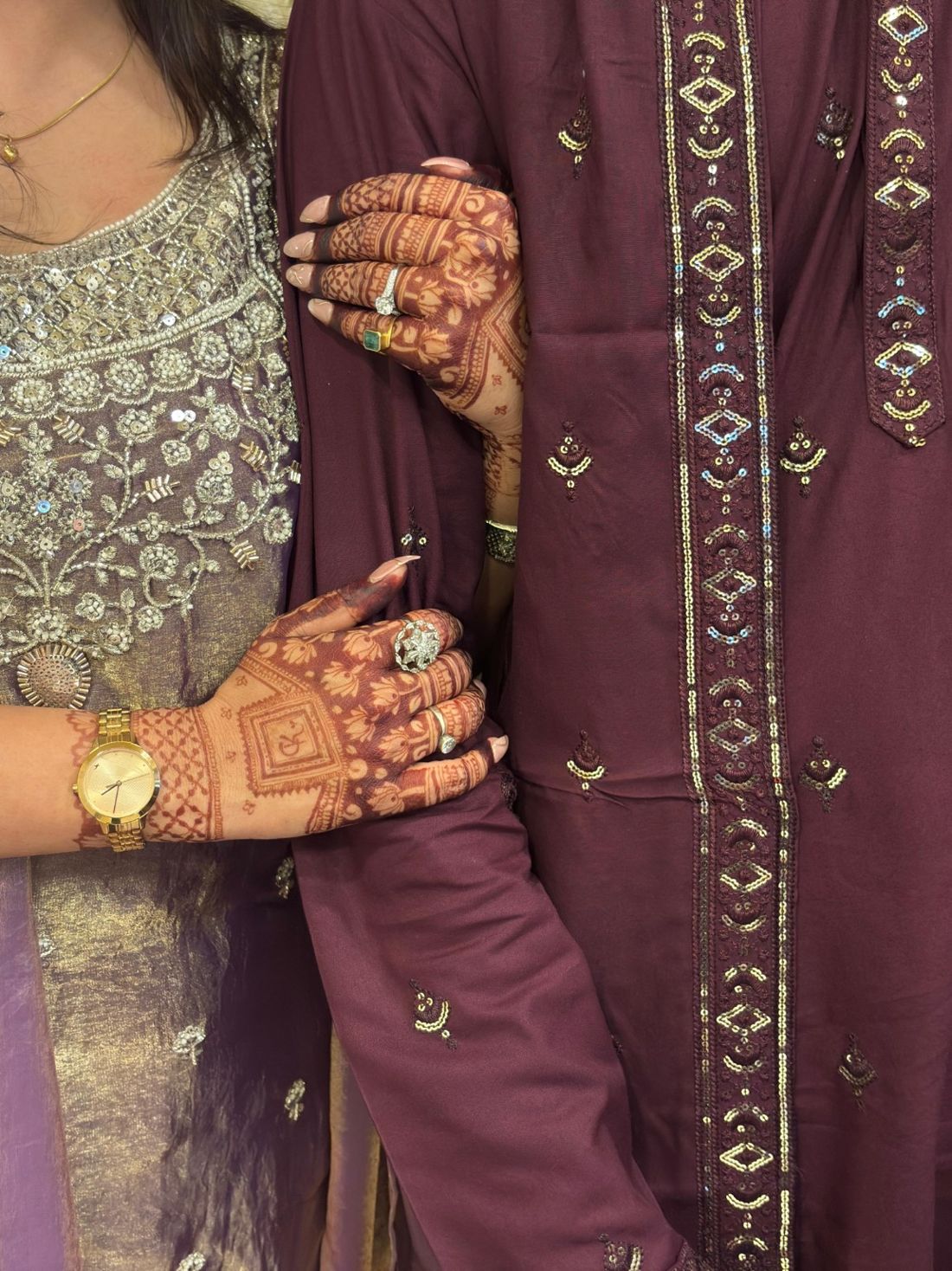 Chanchal's mehendi-covered hands resting on Krish's sleeve